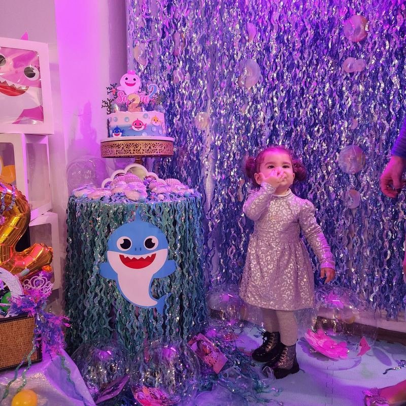 Under-the-sea themed dessert table with shimmering purple backdrop