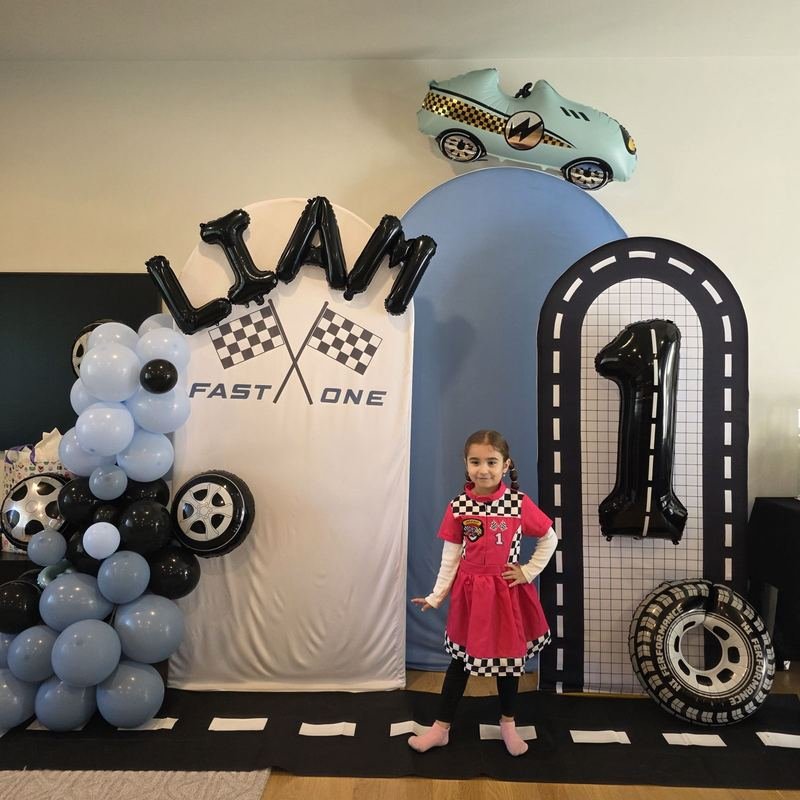 Race-car themed first birthday backdrop with balloon garland