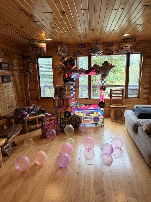 Retro boombox photo booth with disco balls in a wood cabin room